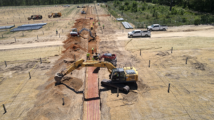 Excavator trenching for electrical conduit at a Pure Power solar project